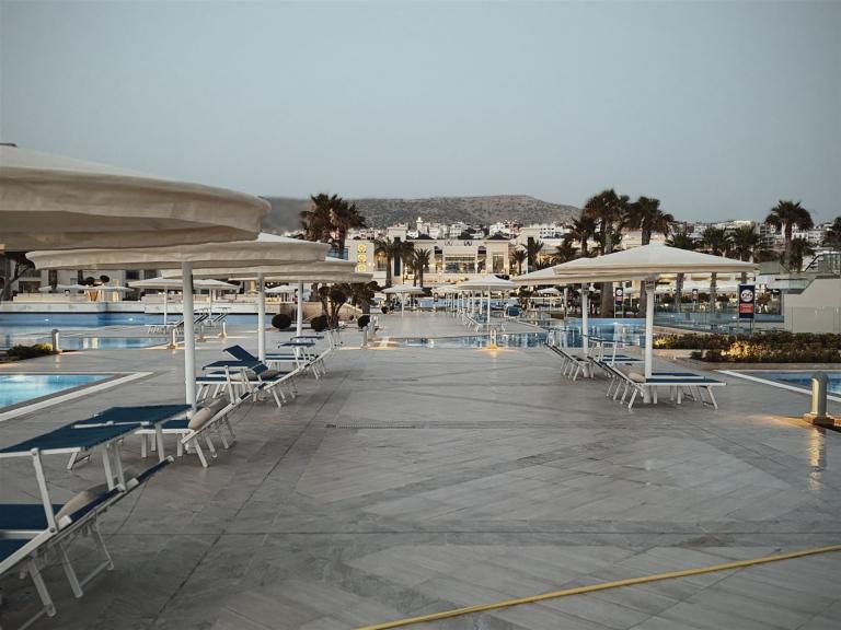 Ein weitläufiger Poolbereich eines Resorts mit vielen weißen Sonnenschirmen und Liegen