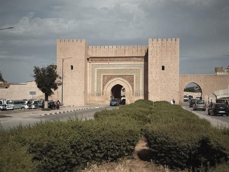 Monumentales historisches Torhaus mit angrenzenden Türmen unter einem bewölkten Himmel